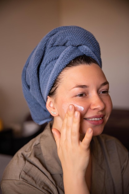 Smile woman look at mirror with cream for face