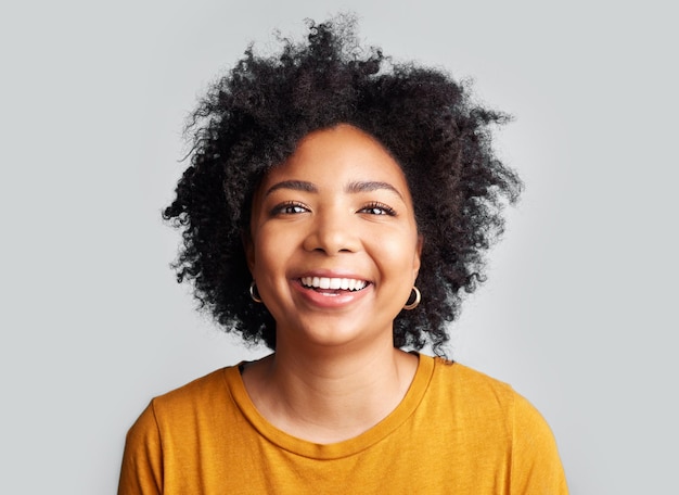 Smile woman and portrait in studio white background and confident on backdrop Face of happy young female model laughing with curly afro hair positive personality and gen z style from South Africa