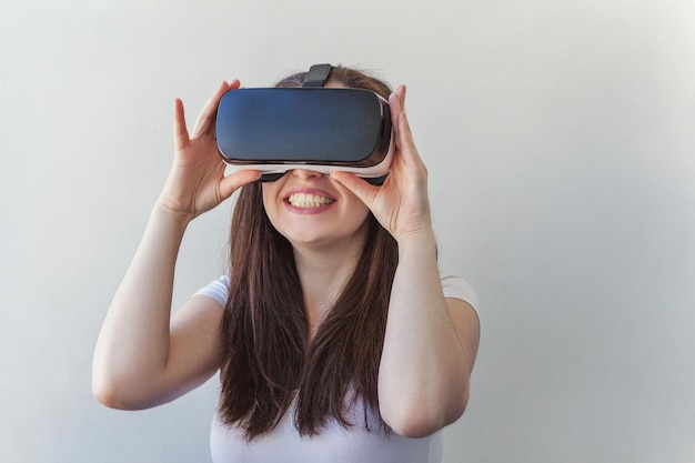 Smile young woman wearing using virtual reality vr glasses helmet headset on white background