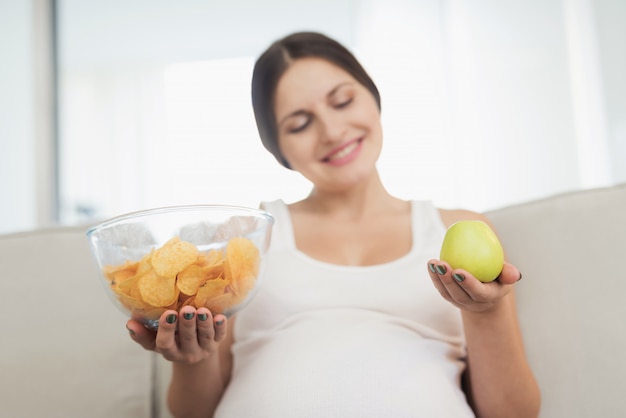 Smiles woman. buik kies een apple of vaas met spaanders.