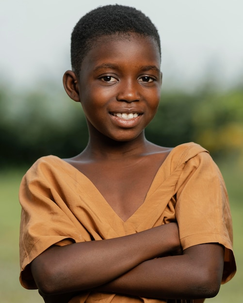 Smiley bambino africano tenendo le braccia incrociate