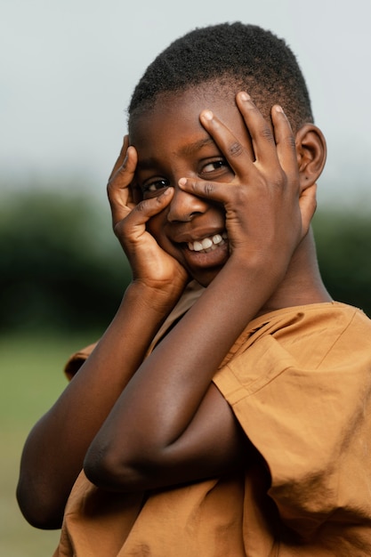 Smiley african child holding hands on face