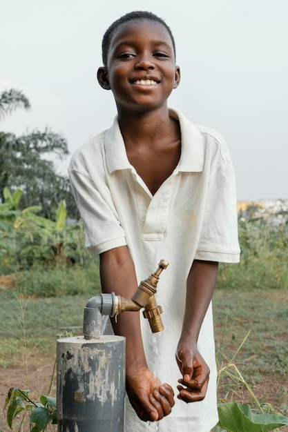 Foto bambino africano di smiley che si lava le mani