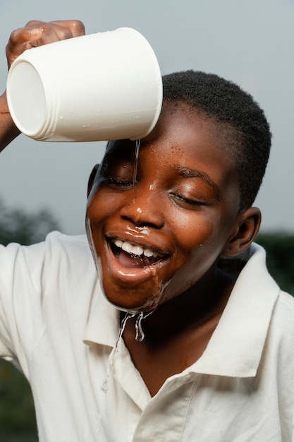 Foto smiley afrikaanse jongen zijn gezicht wassen