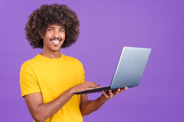 Smiley Afrikaanse man die staat en een laptop gebruikt