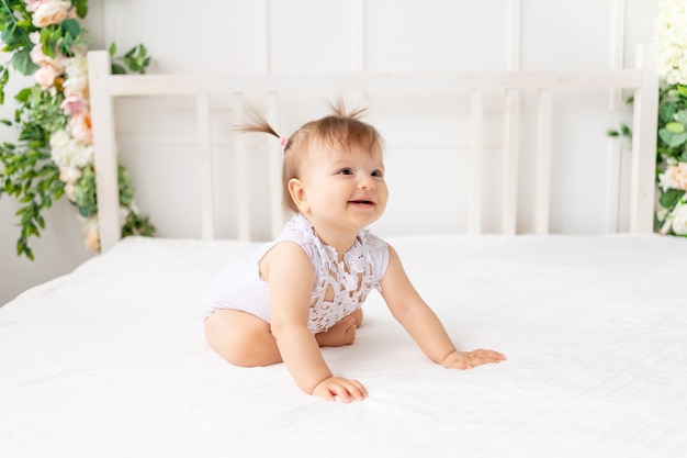 Smiley baby girl sitting on the bed