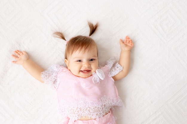 Smiley baby girl sitting on the bed