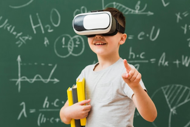 Мальчик смайлик носить гарнитуру виртуальной реальности и проведение книг