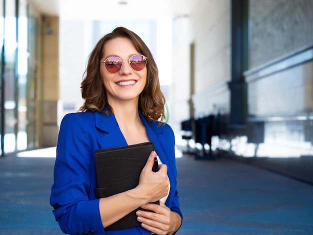 Smiley businesswoman or lawer adjusts her eyeglasses and looking at the camera