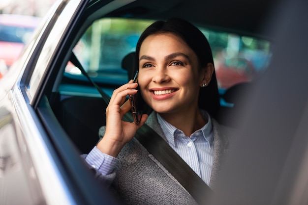 Smiley businesswoman talking on the phone while in the car