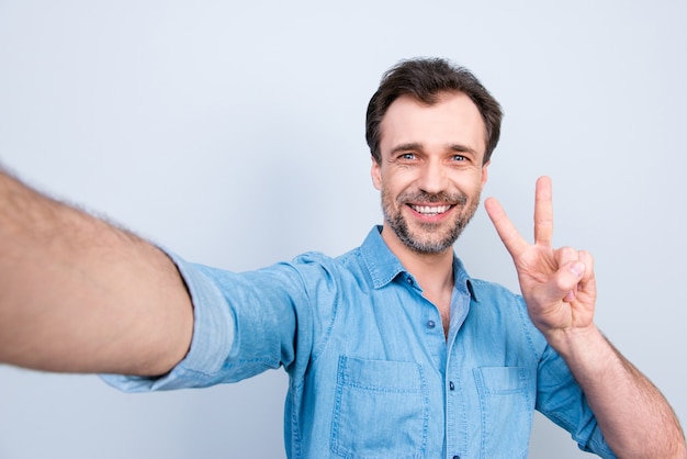 Smiley casual man taking selfie