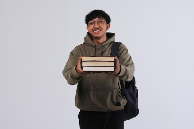 Smiley college student bring books while standing