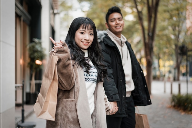 smiley couple with shopping bag on the street