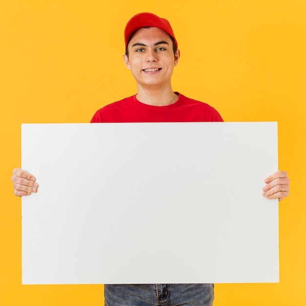 Photo smiley delivery man holding blank paper sheet