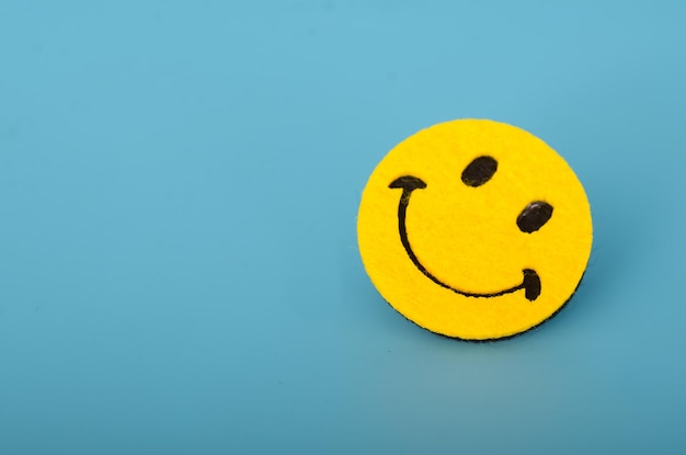 Smiley face emoji on a blue background conveying positivity and cheerful emotions