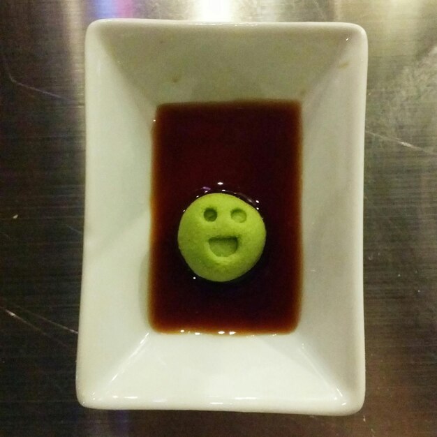 Foto una faccia sorridente su una palla di wasabi in salsa di soia