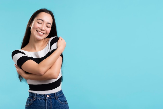 Smiley female hugging herself