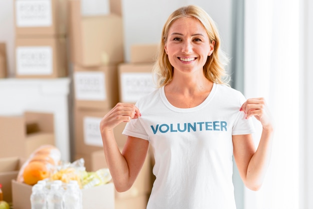 写真 tシャツを披露しながらポーズをとって笑顔の女性ボランティア