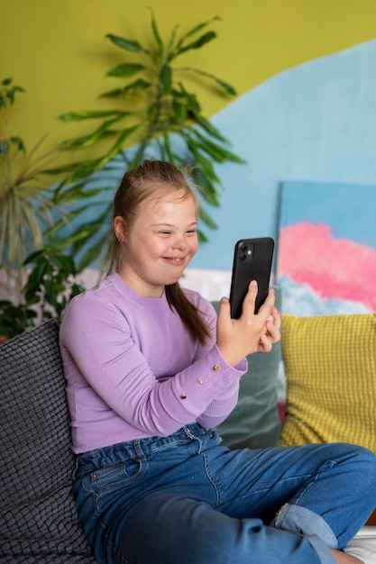 Photo smiley girl holding smartphone side view