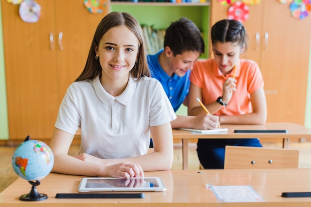 Foto ragazza di smiley che propone in classe