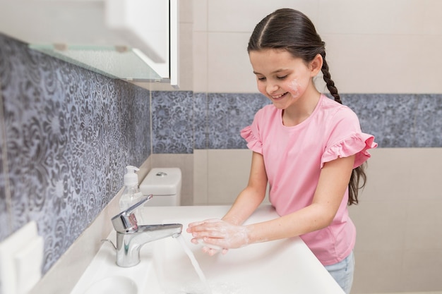 Photo smiley girl washing her hands