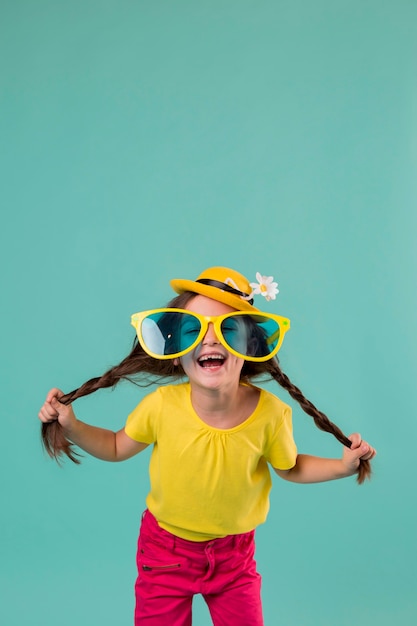 Foto ragazza di smiley con grandi occhiali da sole e copia spazio