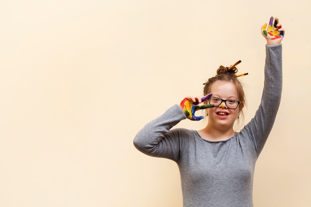 Foto ragazza sorridente con sindrome di down e palme colorate