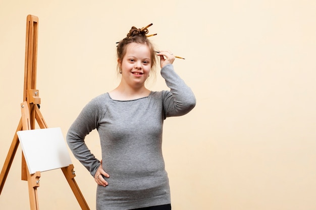 Foto ragazza di smiley con sindrome di down in posa mentre si tiene la spazzola