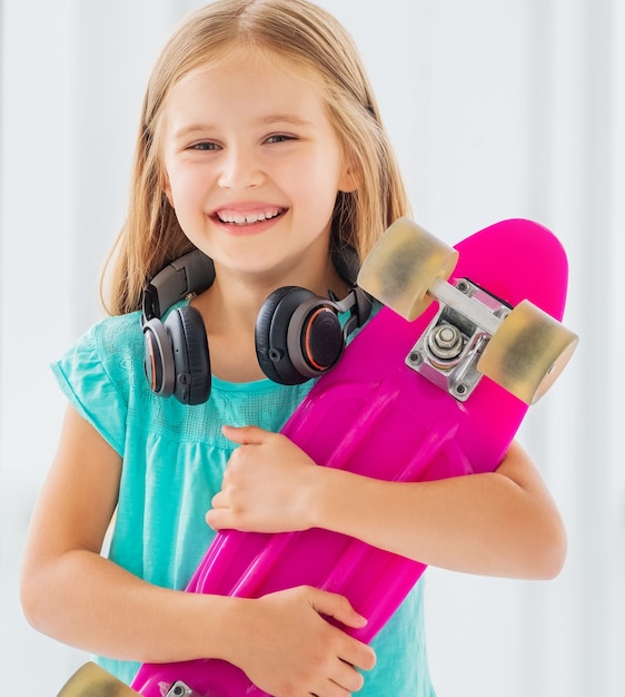 Фото Смайлик девушка с наушниками держит скейтборд