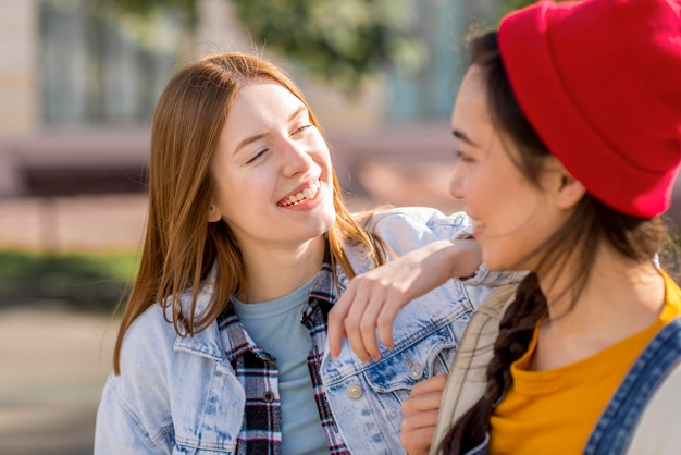 Smiley girlfriends looking at eachother