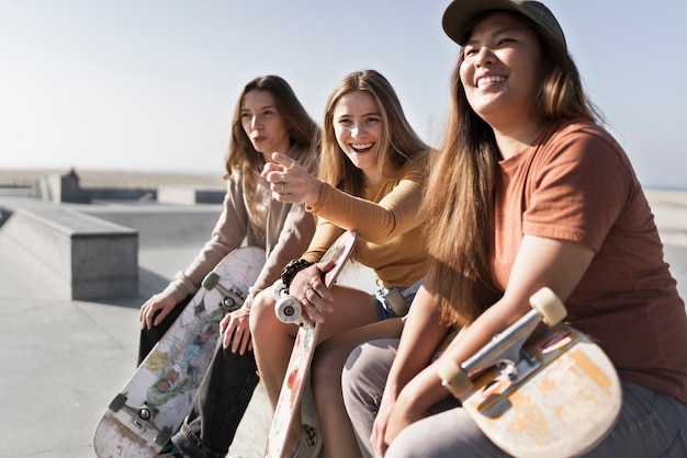 Smiley girls with skateboards medium shot