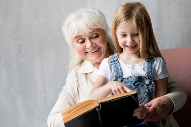 사진 어린 소녀를 위해 읽고 웃는 할머니