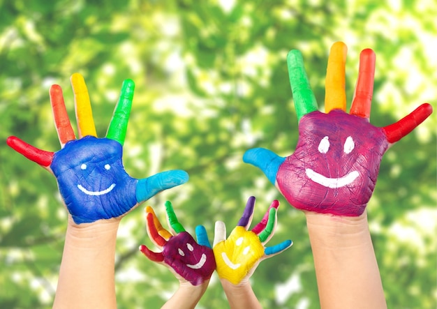 Smiley on hands against green spring background. Family having fun outdoors