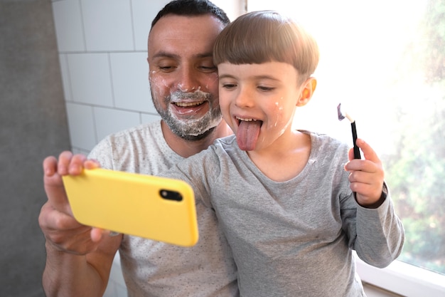 Smiley kid and father taking selfie side view