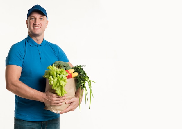 Smiley levering man poseren met boodschappentas