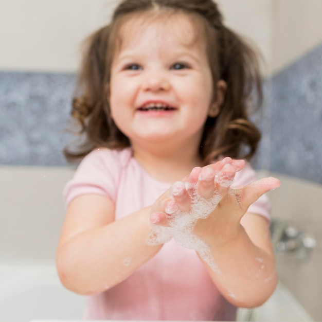 Photo smiley little girl washing hands