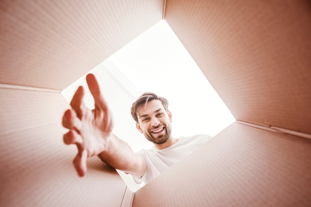 Foto smiley man met gestrekte arm aan de onderkant van de doos weergave