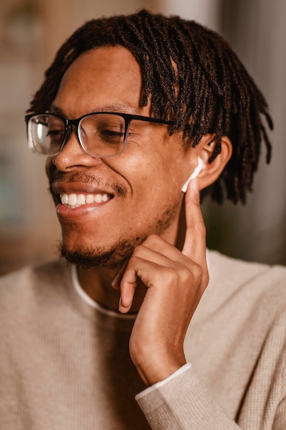 Foto uomo di smiley usando i suoi auricolari