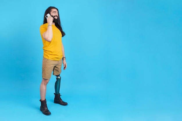 Smiley man with prosthetic leg talking to the mobile phone