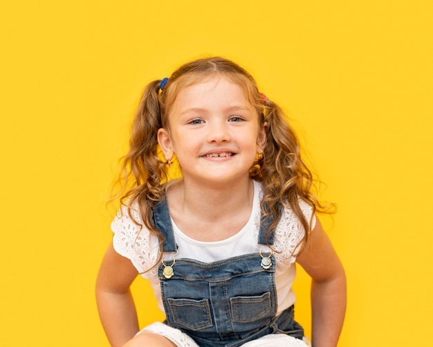 Foto smiley meisje met gele achtergrond