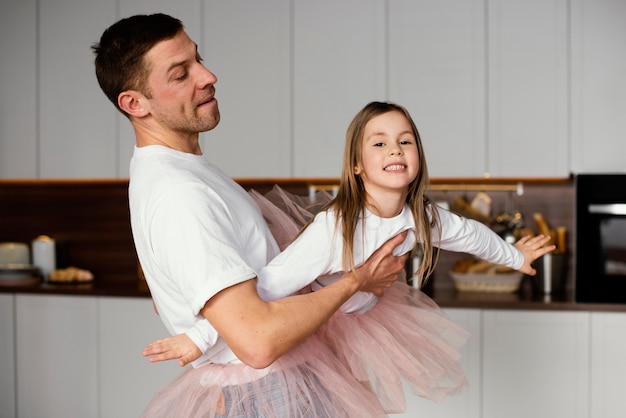 Smiley meisje met plezier met papa in tutu rokken