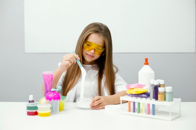 Smiley meisje wetenschapper slijm maken in het laboratorium