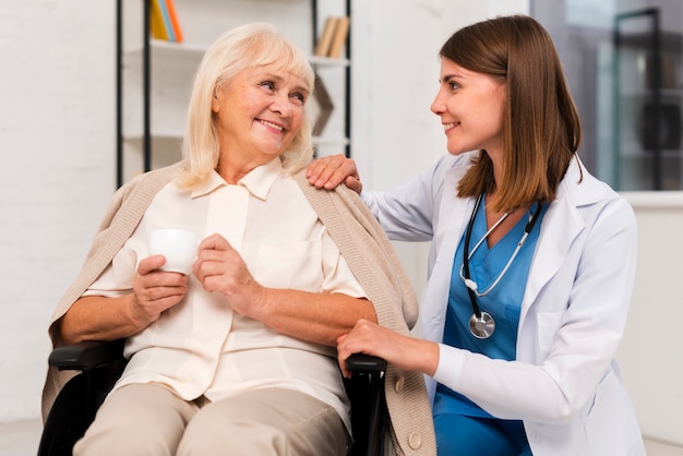 Photo smiley old woman talking to caregiver