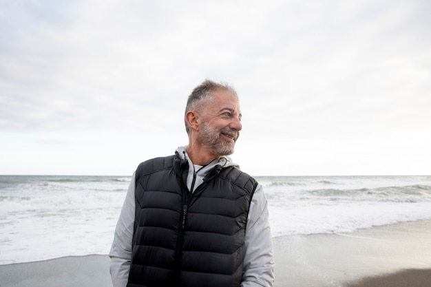 Smiley senior man op strand medium shot