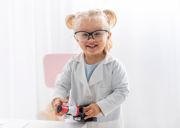 Bambino di smiley con il microscopio