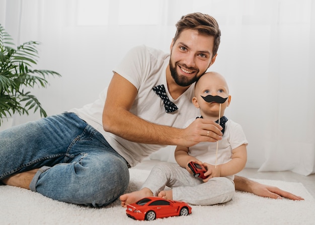 Foto smiley vader poseren met baby tijdens het spelen