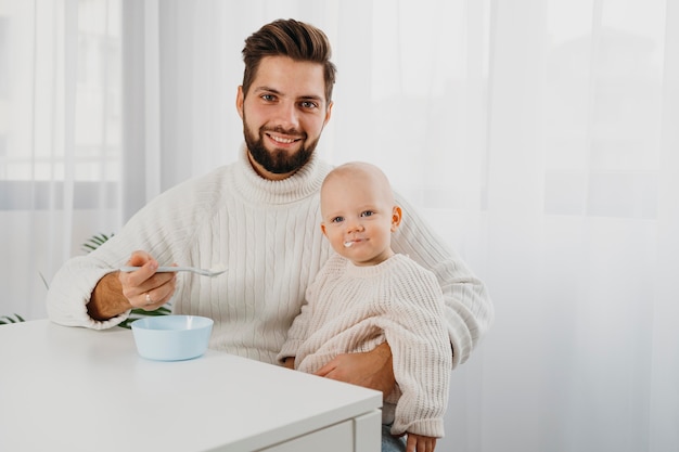 Smiley vader poseren met baby tijdens het voeden