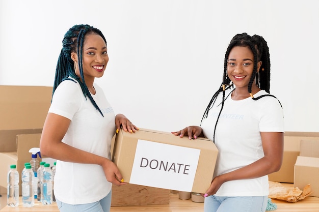 Smiley volunteers holding a box of donations