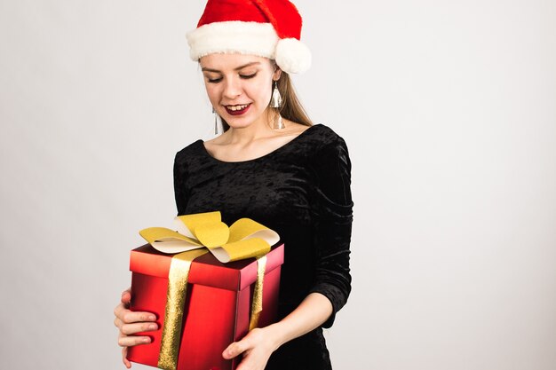 Smiley vrouw met kerstmuts met kerstcadeau