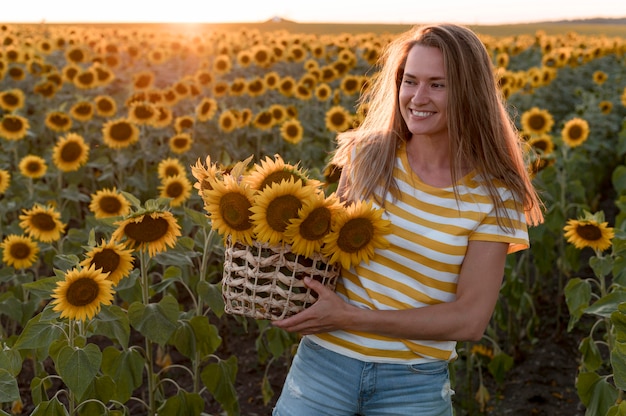 Foto smiley vrouw met zonnebloemen mand